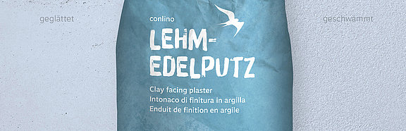 conluto Lehm-Edelputz im Sack (Farbton Lehmblau) vor Wandausschnitt im selben Farbton